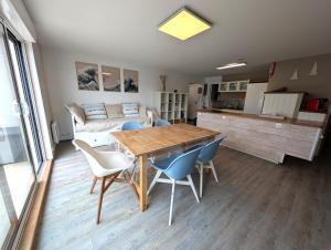 a kitchen and living room with a wooden table and chairs at La vague in Camiers
