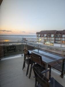 a table and chairs on a balcony with a view of the ocean at La vague in Camiers