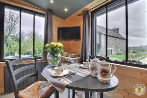 a dining room with a table and a large window at Chez patricia in Ploubazlanec