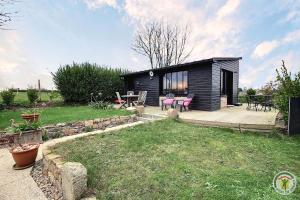 a small black cabin with a deck and a patio at Chez patricia in Ploubazlanec