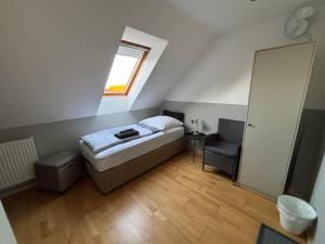 a small bedroom with a bed and a window at Zimmer-Bad-TV-Kühlschrank-16 in Meine