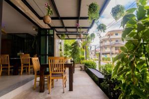 a patio with a table and chairs and plants at Surf & Sand Resort in Hua Hin