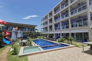 a building with a swimming pool in front of a building at Surf & Sand Resort in Hua Hin
