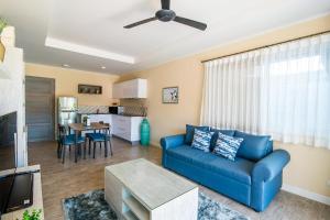 a living room with a blue couch and a kitchen at Surf & Sand Resort in Hua Hin