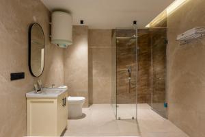 a bathroom with a shower and a toilet and a sink at The Hi-Rise in Gurgaon +67 photos