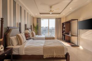 a bedroom with two beds and a large window at The Hi-Rise in Gurgaon
