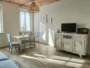 a dining room with a table with chairs and a tv at B&B Barba Vigin in San Damiano dʼAsti
