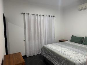 a bedroom with a bed and white curtains at Casa da Lua, com espaço gourmet no Lubango, Huila in Lubango