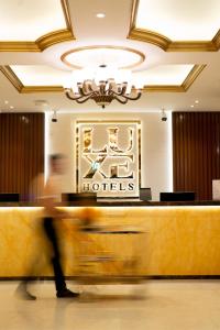 a person walking past a hotel lobby at Luxe Avenue Hotel in Dubai