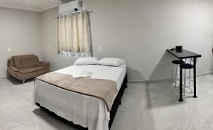 a hospital room with a bed and a chair at Kitnet Moderna com Ar e Vaga Privativa Coberta in Votorantim