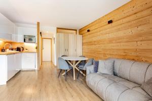 a living room with a couch and a table at L'Alpage - Serre Chevalier in Saint-Chaffrey