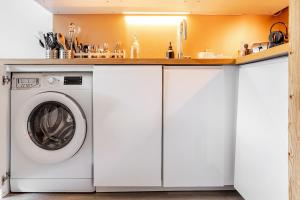 a kitchen with a washer and dryer under a counter at L'Alpage - Serre Chevalier in Saint-Chaffrey