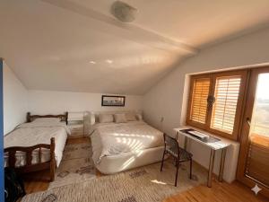 a bedroom with two beds and a desk and a window at Entire Villa or Rooms! Spacious Villa in Nizepole Hiking, Peace, Private Events in Bitola