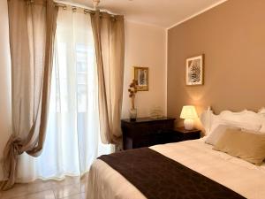 a bedroom with a bed and a large window at Blue Dolphin Guest House in Alghero
