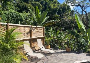 two white chairs sitting on a wooden deck at Le Bananawi in Pointe-Noire