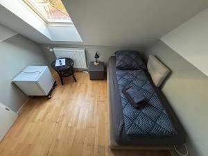 a small room with a bed in a attic at Zimmer-Bad-TV-Kühlschrank-14 in Meine