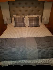 a large bed with two pillows and a blanket at Cohannon Inn in Dungannon