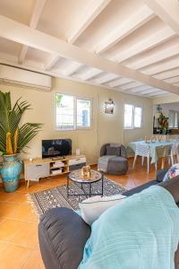 a living room with a couch and a tv at Kaz KOKOYE in Baie-Mahault