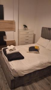 a large bed with towels and a dresser in a bedroom at Zak Air B&B Stay 9 people's in Birmingham
