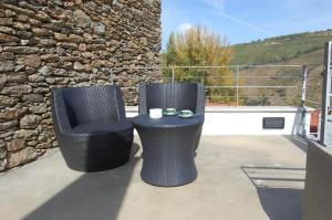 two chairs and a table on a patio at Quinta dos Castanheiros - Turismo Rural in Negreda