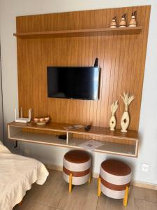 a bedroom with a desk with a tv and two stools at Cantinho do Aconchego in São Lourenço