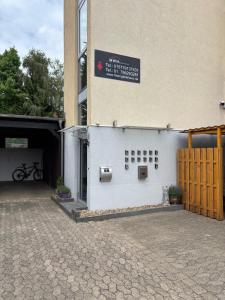 a white building with a gate and a building with a sign at Zimmer-Bad-TV-Kühlschrank-14 in Meine