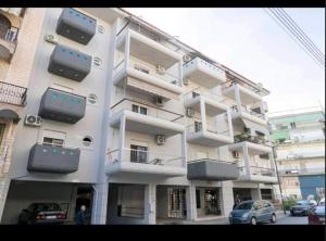 a large white building with balconies on the side of it at Central appartment 2 with parking in Larisa