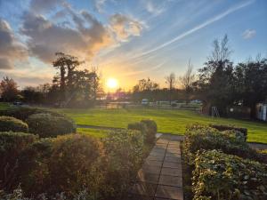a sunset in a park with the sun setting at Harbour View Lodge in Dromod