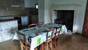 a kitchen with a long table and chairs in a room at Le Gîte de Mayac,16 rue du four à pain, 24600 VILLETOUREIX FRANCE in Villetoureix