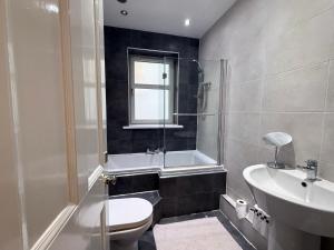 a bathroom with a toilet and a tub and a sink at The Orchard Hotel in Falkirk +50 photos