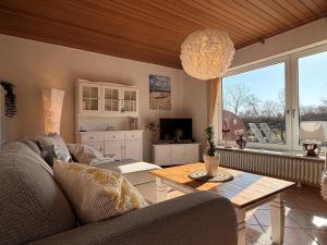 a living room with a couch and a table at Haus Ruhewinkel, Bungalow 2 in Alkersum