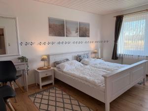 a bedroom with a white bed with blue stars on the wall at Haus Ruhewinkel, Bungalow 2 in Alkersum
