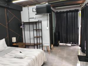 a bedroom with a bed and a flat screen tv at Casa del Pintor Chetumal in Chetumal