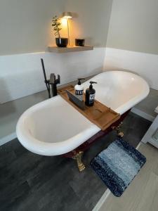 a bath tub with a wooden tray on top of it at Sip and Soak, hotel-style room in Calgary