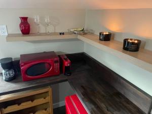 a microwave sitting on a counter in a kitchen at Sip and Soak, hotel-style room in Calgary +7 photos