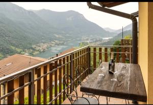 a wooden table on a balcony with a view of a river at La Magia del Lago in Ranzanico