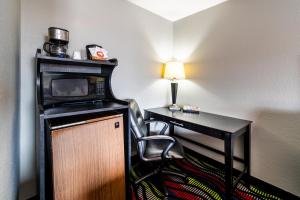 a room with a desk with a microwave and a chair at Sunset Motel and RV in Alliance