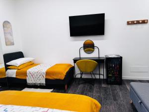 a bedroom with two beds and a tv on the wall at Affittacamere il Conte Rooms in Pescara