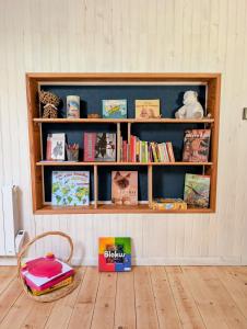 a book shelf in a room with books on it at Le Chant des Arbres in Grane