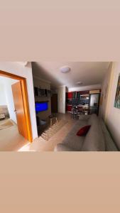 a living room with a large couch and a kitchen at Teddy Apartment in Durrës