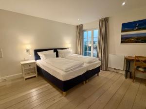 a bedroom with a large bed and a window at Salig Hüs in Kampen