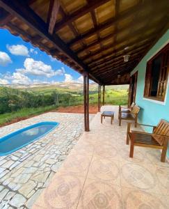 a patio with a table and chairs and a pool at Sítio Anna in São Thomé das Letras