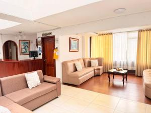 a living room with two couches and a table at Hotel Dinastia in Ipiales