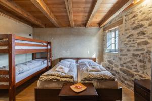a bedroom with two bunk beds and a table at Rifugio Ca' da Cardella in Mendatica