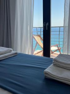 a bedroom with a bed with a view of the ocean at The Yacht House in Agios Ioannis Pelio