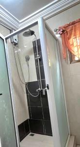 a shower in a bathroom with a glass door at Aburi Emerald Garden Retreat in Aburi