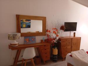 een kamer met een houten dressoir met een spiegel en een bureau bij Colibri des îles in Le Gosier