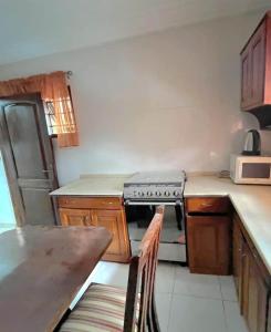 a small kitchen with a stove and a refrigerator at Aburi Emerald Garden Retreat in Aburi +66 photos