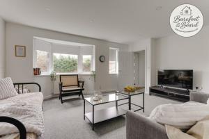 a living room with a couch and a table at Contractor friendly 3BDR Home | Parking for Vans in Salford