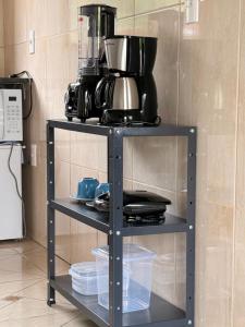 a shelf with pots and pans on it in a kitchen at Chalés recanto dos oliveira in Camanducaia